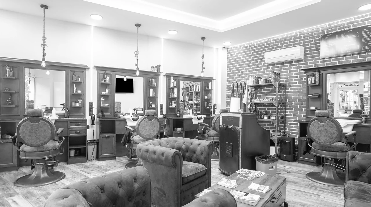 Coin chaleureux d'un salon de barbier vintage — fauteuil en cuir, briques et ampoule Edison