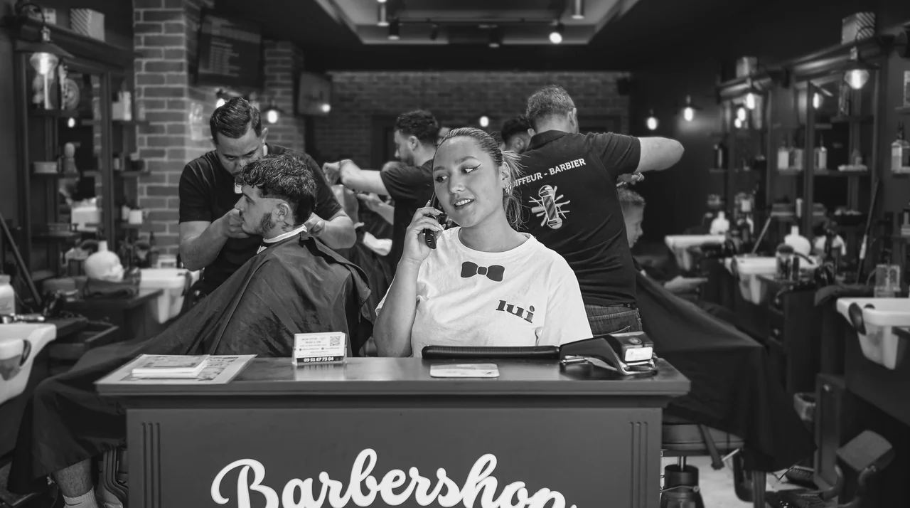 Accueil du salon Lui Coiffeur de Fréjus : barbiers au travail derrière le comptoir « Barbershop »