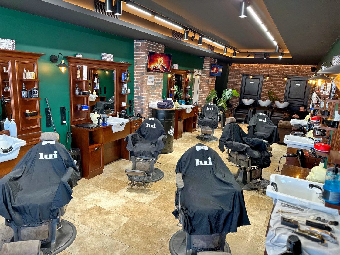 Intérieur du salon Lui Coiffeur à Fréjus : fauteuils de barbier vintage et capes Lui