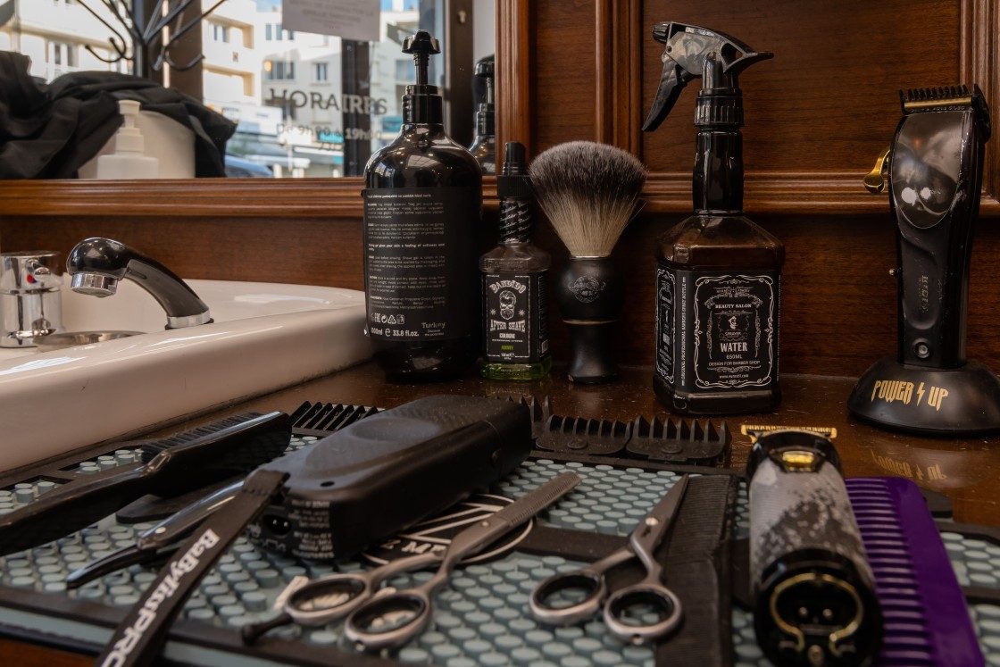 Outils de barbier sur le plan de travail : tondeuses, ciseaux, blaireau et flacons au salon Lui Coiffeur à Sainte-Maxime
